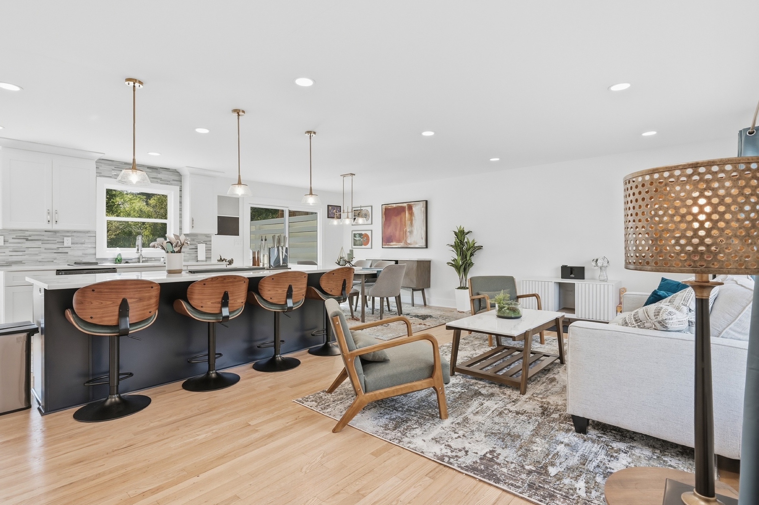 Open concept kitchen and living room in flat daytime light before evening conversion