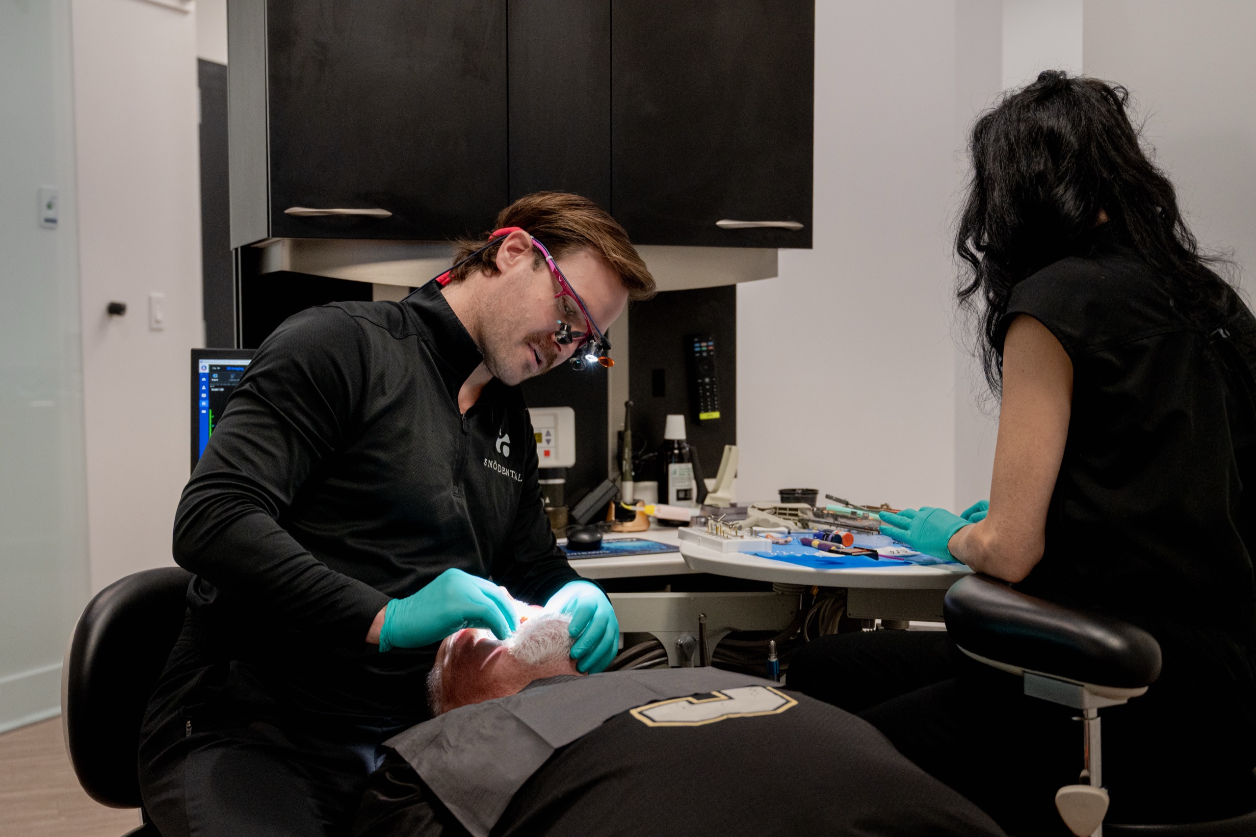 Dentist performing a procedure with a patient at SNOdental