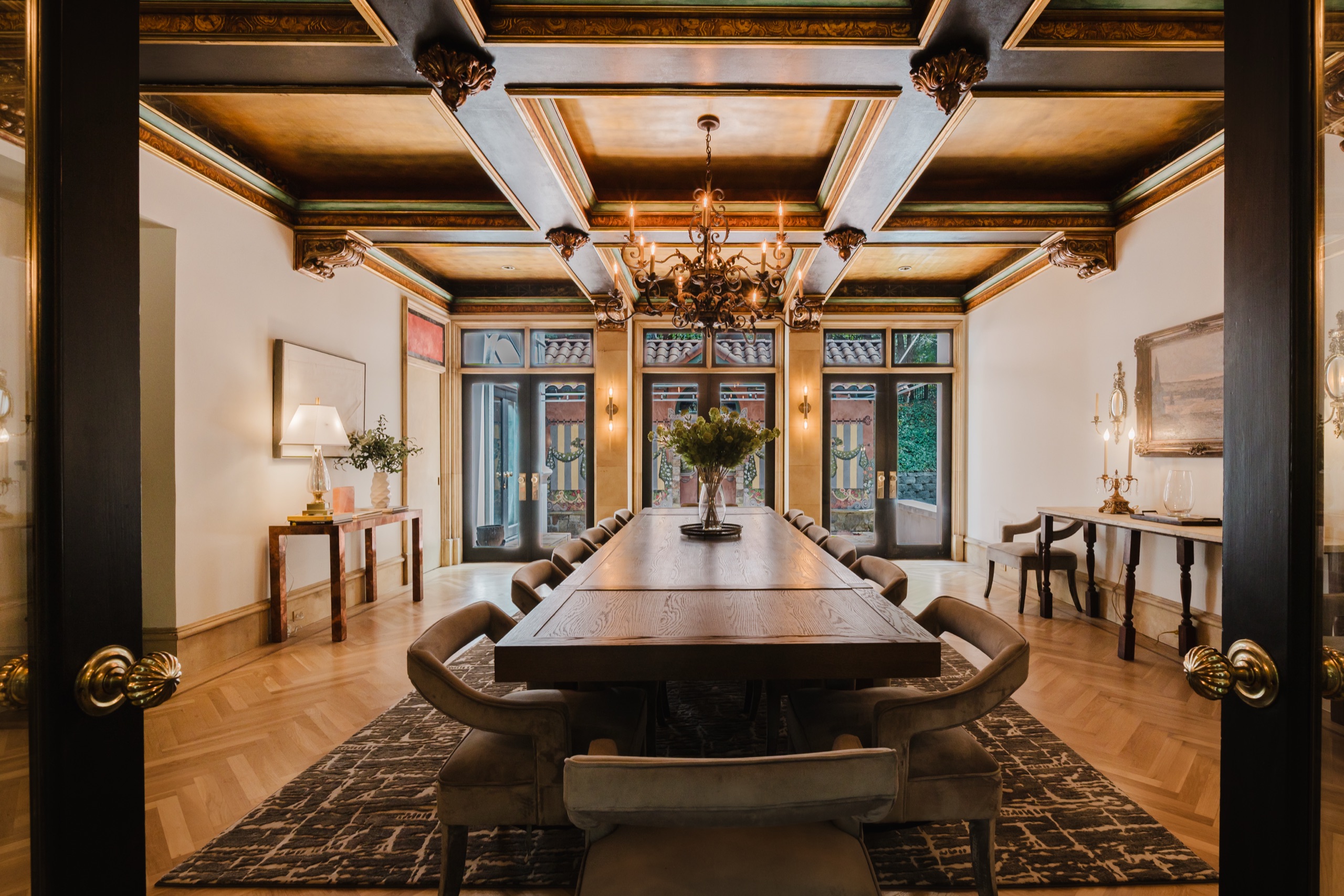 Estate dining room with coffered gold ceiling and long designer table